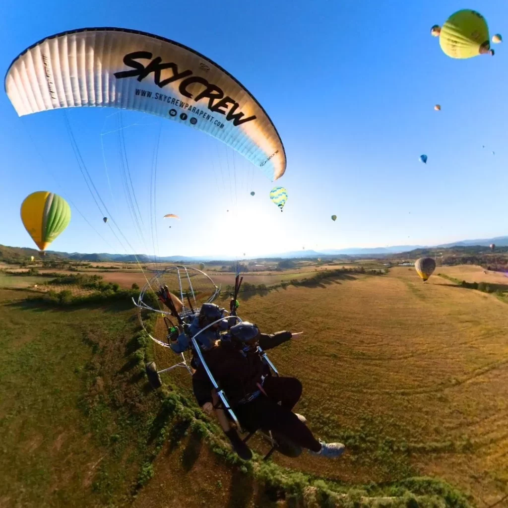 Passatger emocionat durant un vol en paramotor entre globus aerostàtics a Igualada