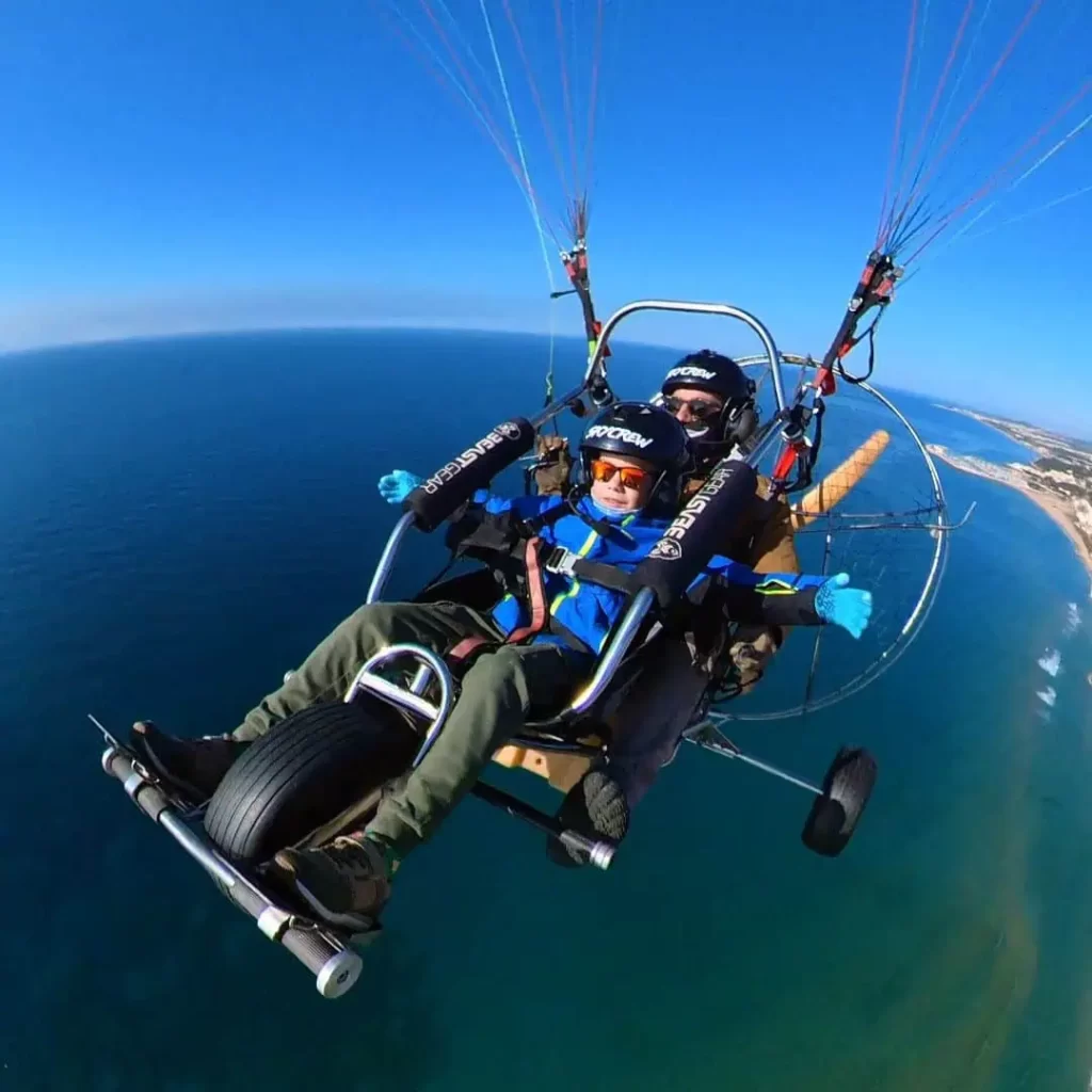 Infant volant en parapent biplaça amb pilot professional, activitat segura per famílies